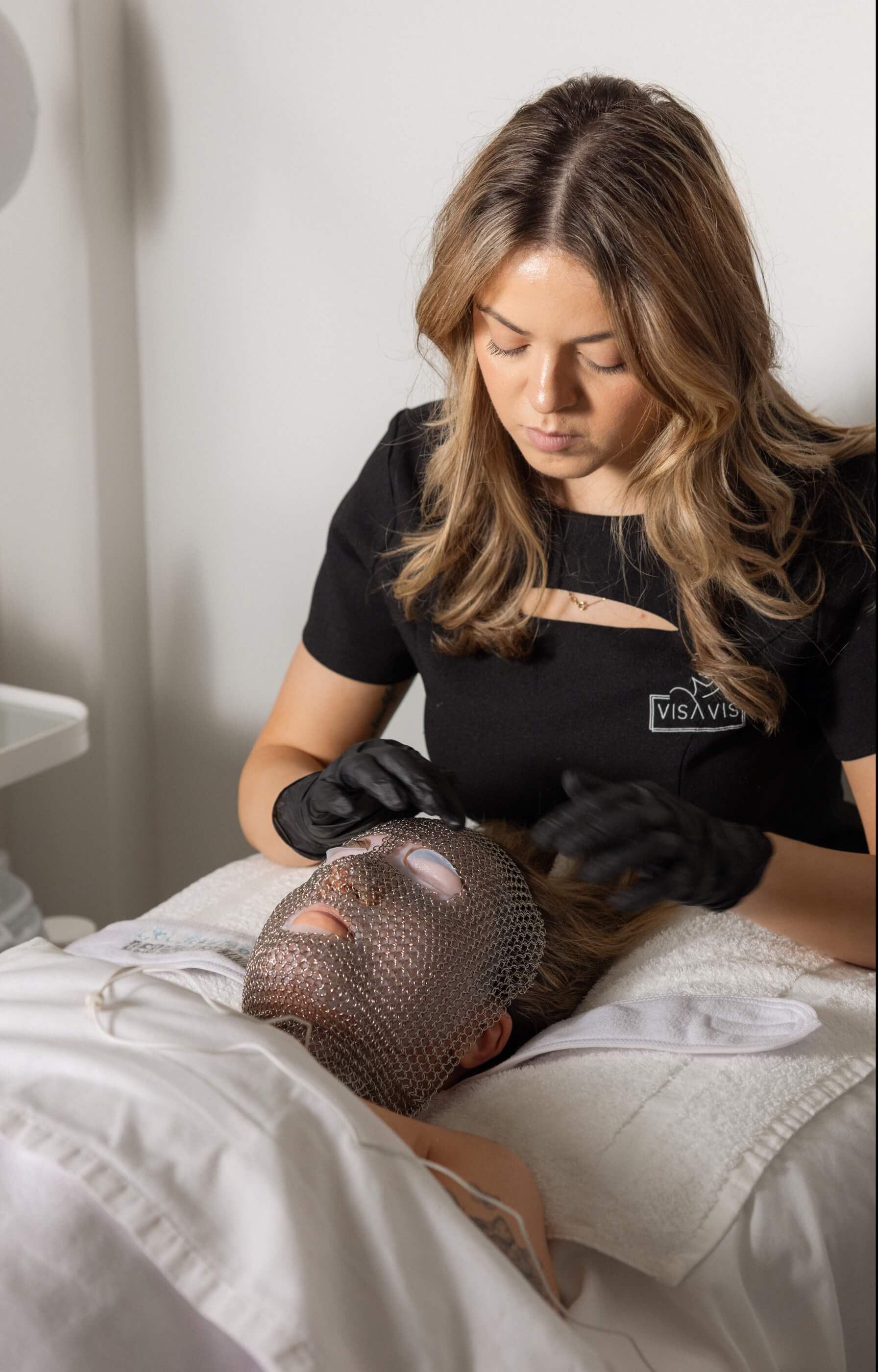 Vis A Vis esthetician applying exclusive chain mask during LIFTED facial using Dermotechnology