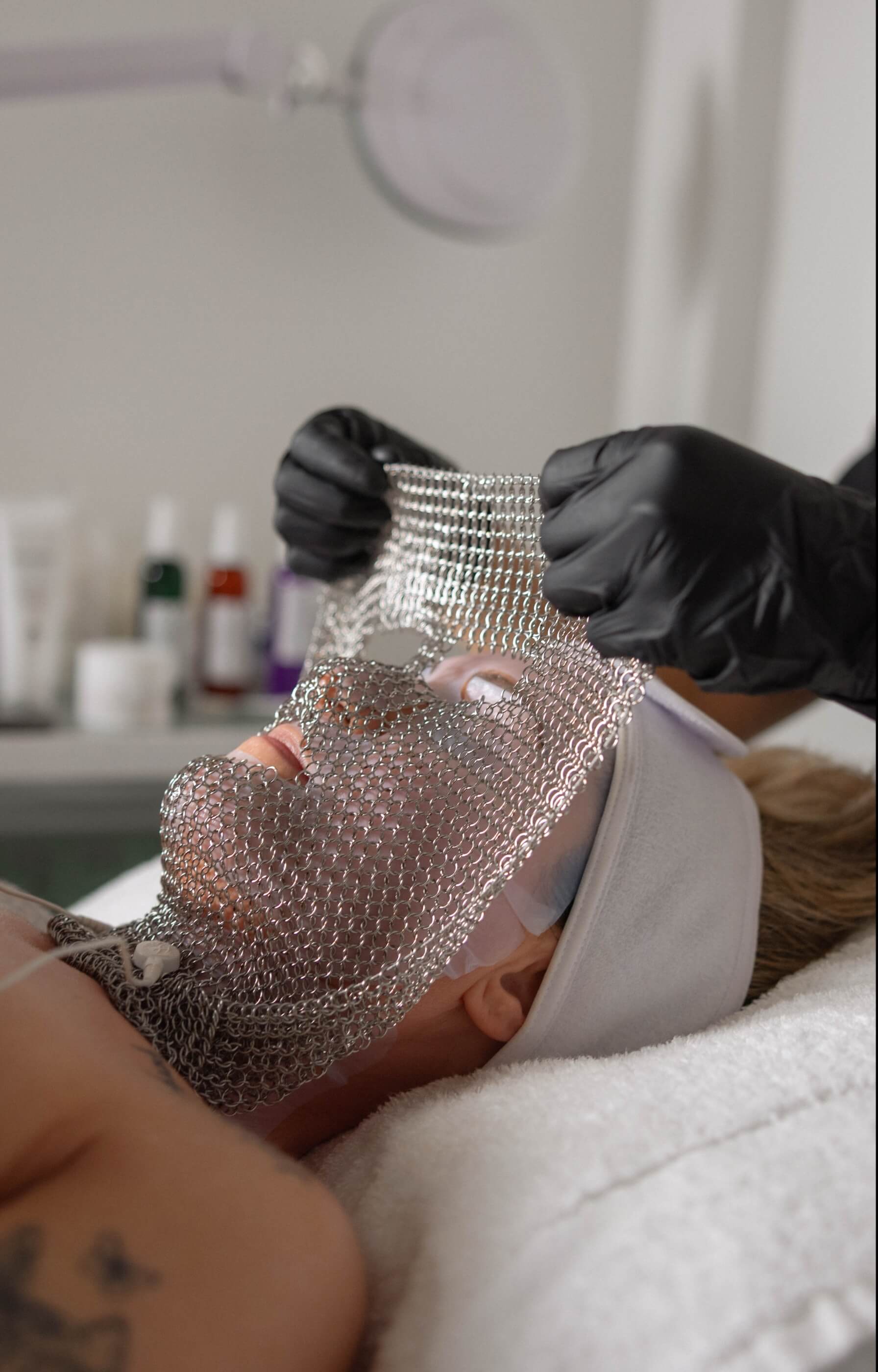 Close-up of silver chain mask being removed during the LIFTED facial at Vis 
A Vis spa.