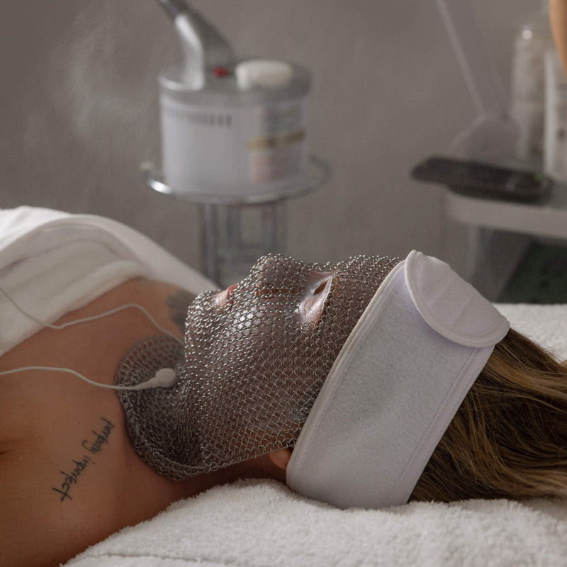 Relaxing moment during the LIFTED facial at Vis A Vis, featuring facial misting and the signature silver chain mask.