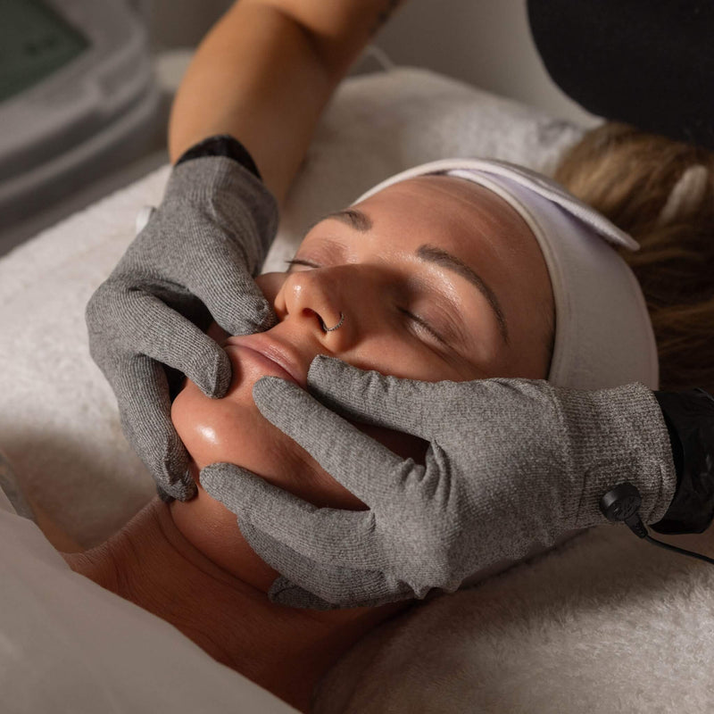 LIFTED facial treatment in progress at Vis A Vis, using silver gloves to sculpt and tone facial muscles with triple microcurrent.