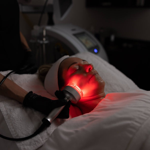 Client receiving red LED light therapy on lower face during advanced facial at Vis A Vis Toronto.