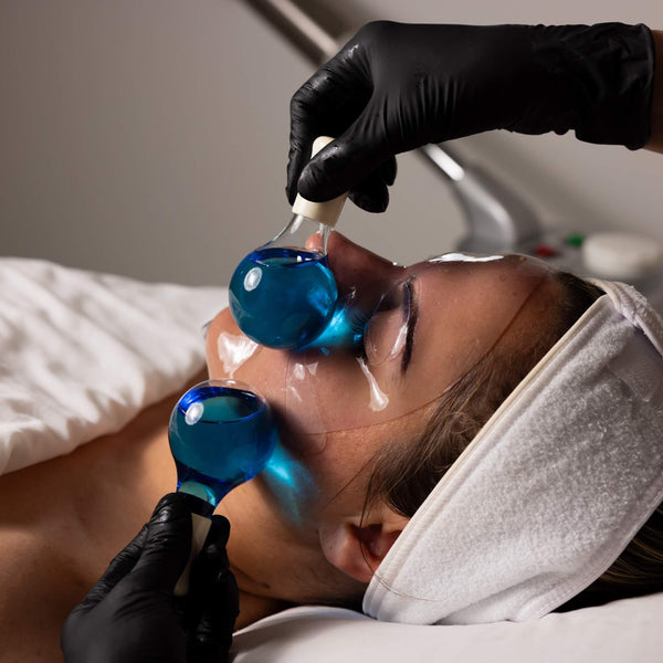 Client receiving cryo ice globe massage during Skin-Refresh facial at Vis a Vis in Toronto. Calming and de-puffing summer skincare.